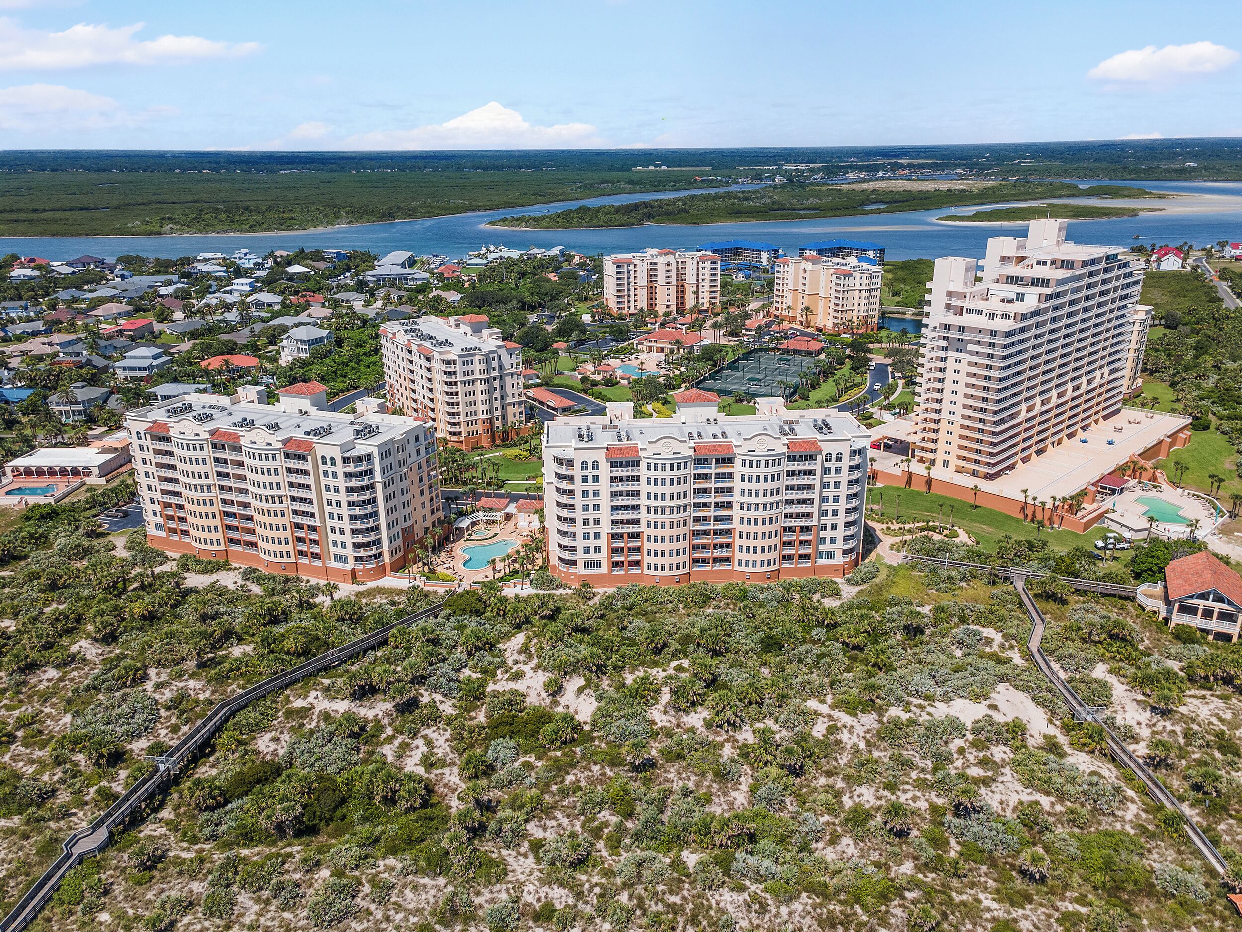 Un hôtel de grande hauteur, avec de nombreux étages, une piscine et une vue sur une rivière.