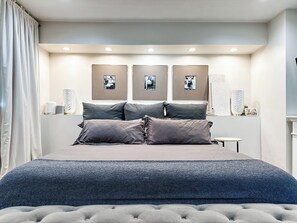 A bedroom with a bed, pillows, a bedside table, and wall-mounted pictures. - Perfect for Every Adventurer! Visit for venues and views (Phoenix)