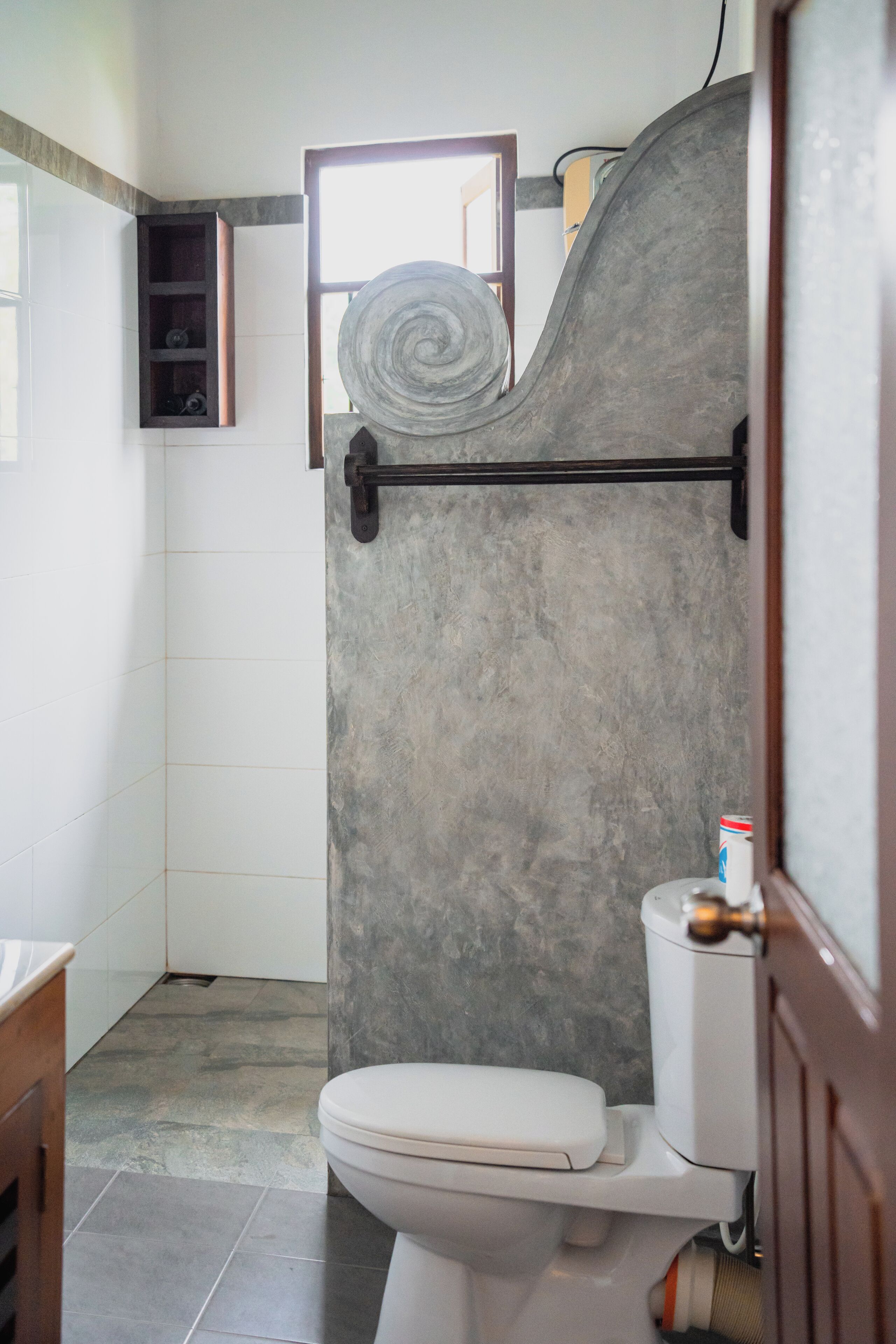 Un bagno con il water, un portasciugamani e una zona doccia.