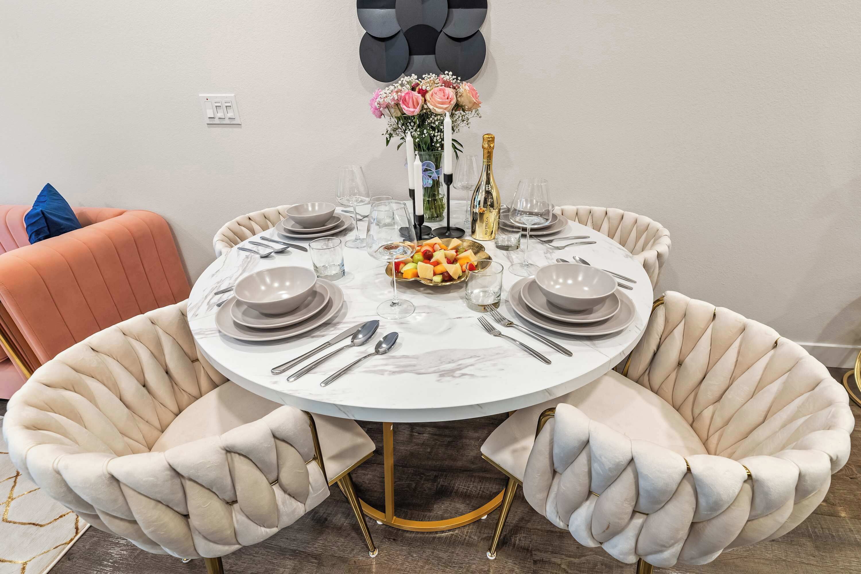 An elegant marble dining table set for four, surrounded by plush quilted chairs — the perfect place to share a slow breakfast or a late-night toast.