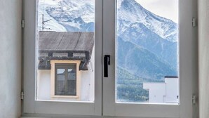 Una habitación con ventana que da a una montaña nevada.