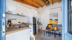 Una cucina moderna con mobili bianchi, un frigorifero in acciaio inossidabile e un piano di lavoro in legno.