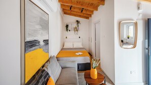 Una stanza moderna con soffitto in legno, un grande quadro astratto, una poltrona, un comodino con un vaso e uno specchio.