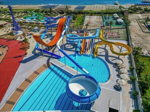 A water park with multiple slides and pools, surrounded by beach areas and umbrellas. - Grand Cortez Halal Family Hotel - All Inclusive  (Alanya)