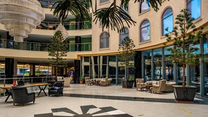 A spacious lobby with a modern chandelier, multiple seating areas, and large windows. - Grand Cortez Halal Family Hotel - All Inclusive  (Alanya)