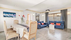 A spacious living area with a dining table, chairs, a sofa, and a coffee table. - Villa Bart - Four Bedroom Villa, Sleeps 8 (Bel-Air)