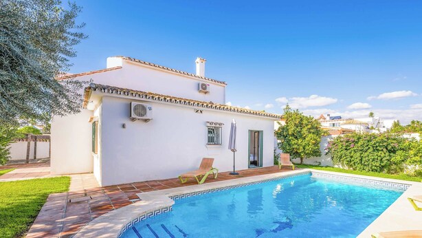 A swimming pool with a tiled deck, a white building with a tiled roof, and a green lawn. - Villa Bart - Four Bedroom Villa, Sleeps 8 (Bel-Air)