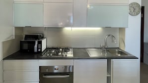 A modern kitchen with a built-in oven, microwave, and gas stove. - Delux-The Terrace Over The Marine Park (Quartu Sant'Elena)