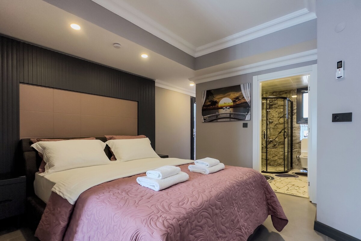 Una habitación de hotel con una cama grande, zona de ducha y baño.