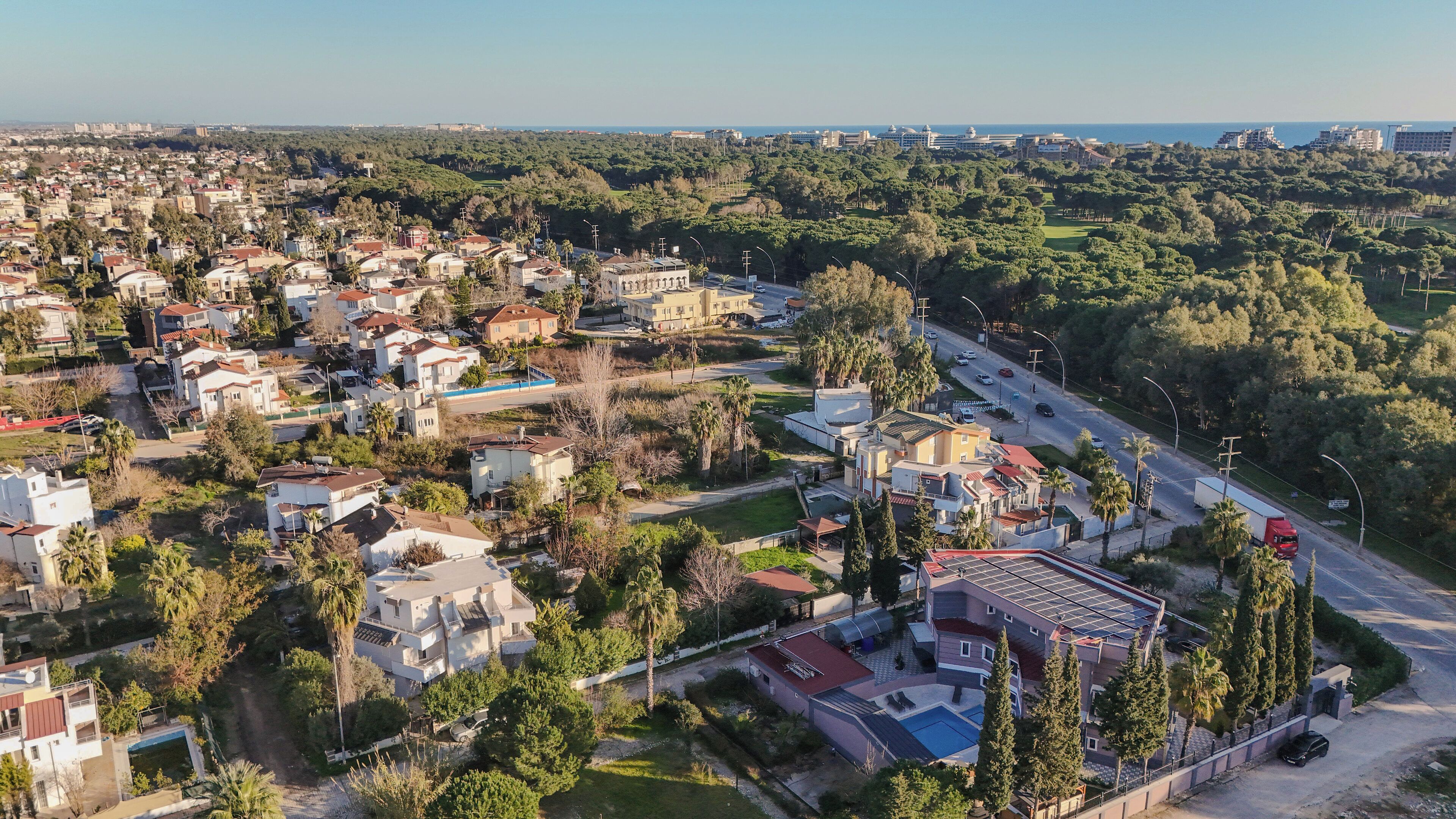 An aerial view of a residential area with houses, roads, and greenery.