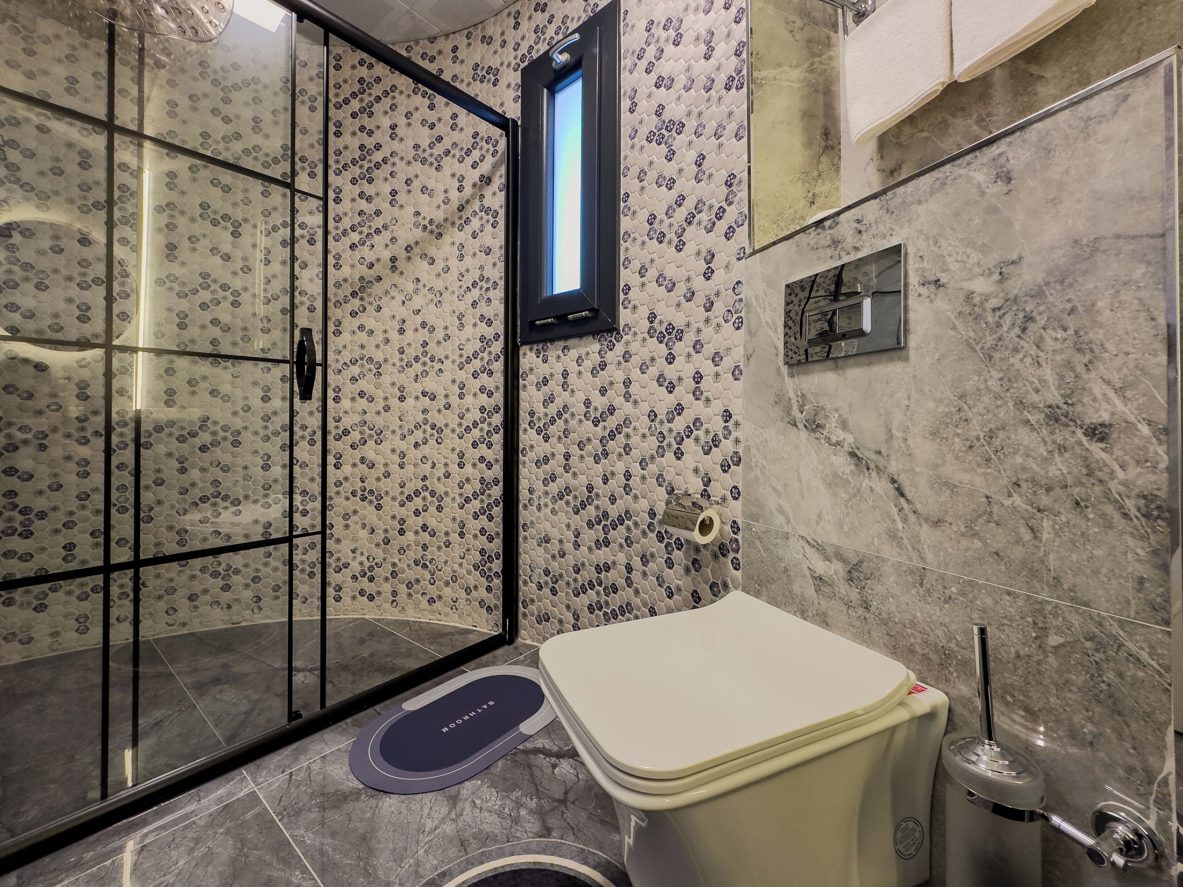 A bathroom with a toilet, bidet, and glass shower enclosure.