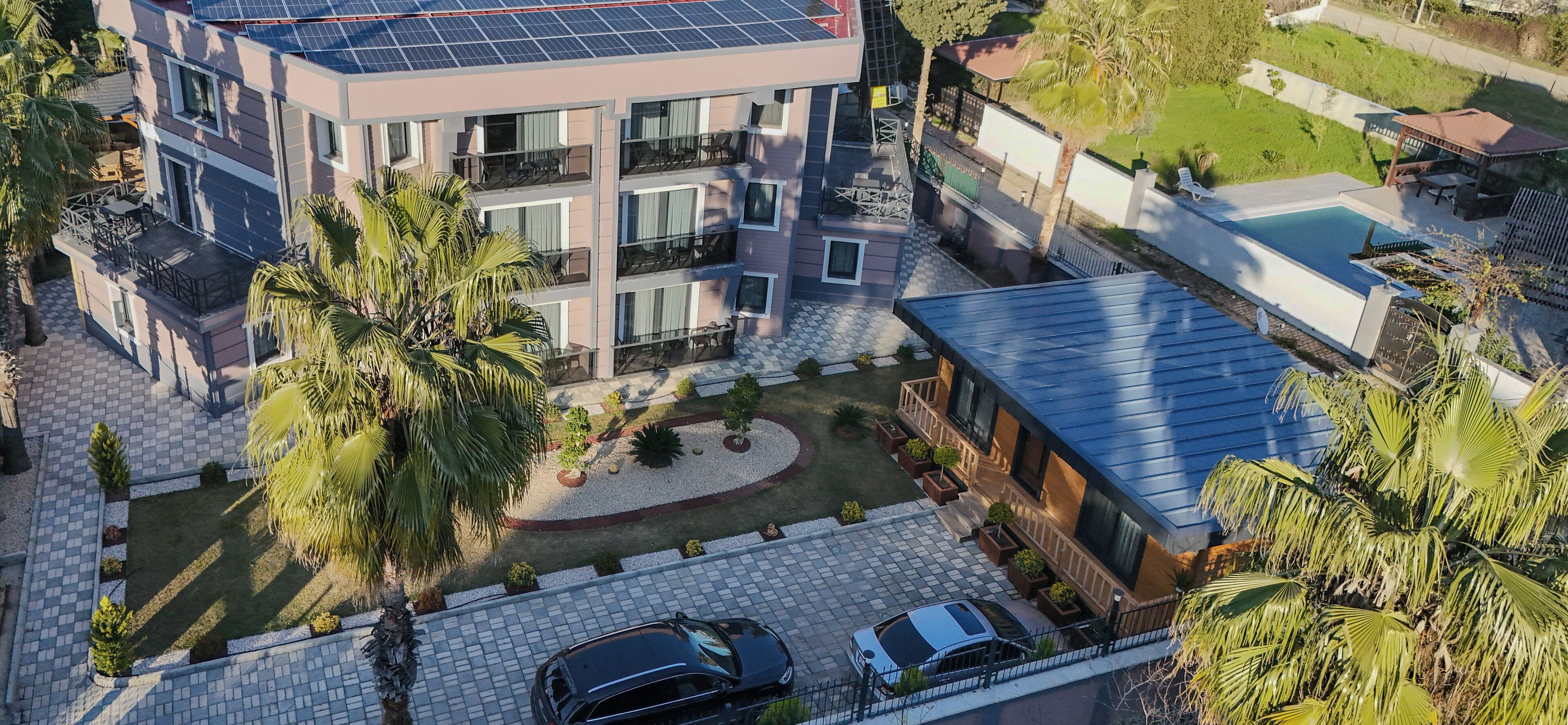 A multi-story building with balconies, a swimming pool, and a carport.