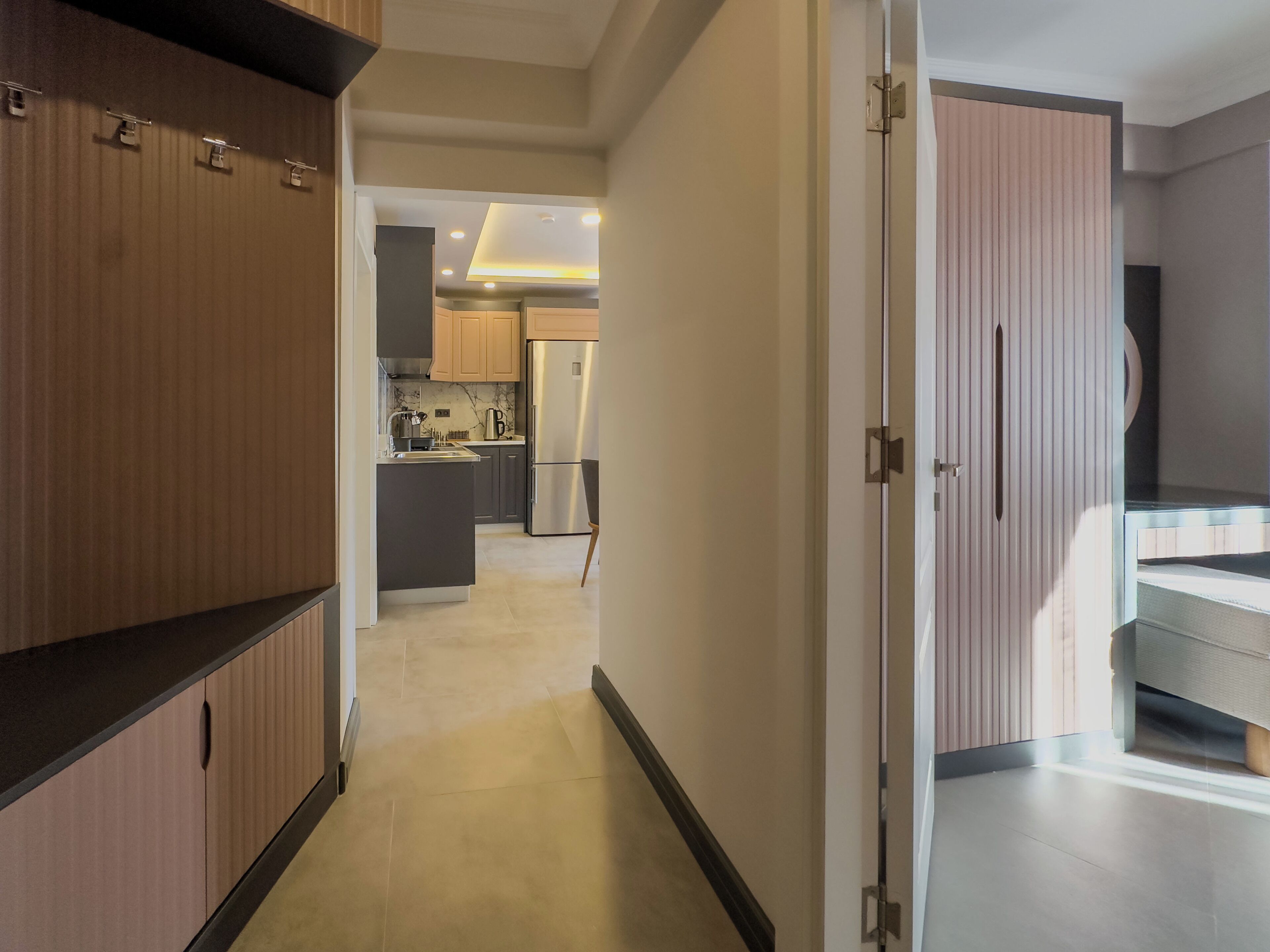 Una cocina moderna con una isla central, armarios de madera y un refrigerador de acero inoxidable.