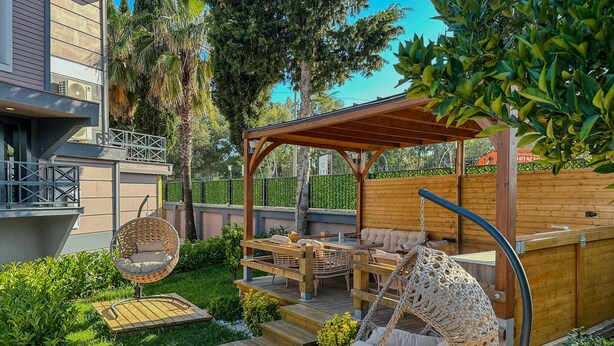 A patio area with wicker chairs, a wooden deck, and a pergola. - Belek 07 Luxury Suites Only For Family (Serik)