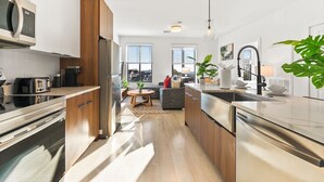 A modern kitchen with stainless steel appliances, wooden cabinets, and a central island.