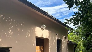 An outdoor patio with a white table and metal chairs, a brick fireplace, and a small window. - B&B "Il Melograno" cottage with private pool in Pistoia. (Pistoia)