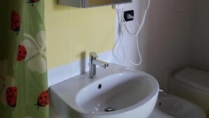 Een badkamer met wastafel, spiegel en toilet.