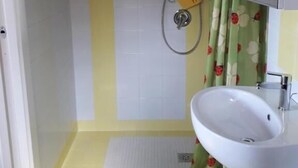 Een badkamer met een douche, wastafel en toilet.