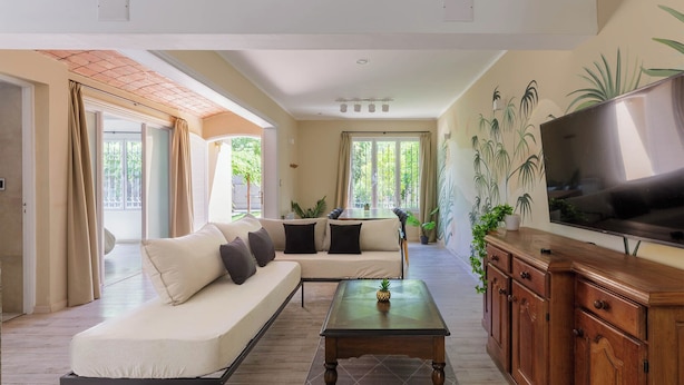 A modern living room with a sofa, coffee table, TV, and wooden cabinet. - MOT Besares (Chacras de Coria)