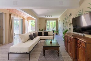 A modern living room with a sofa, coffee table, TV, and wooden cabinet. - MOT Besares (Chacras de Coria)