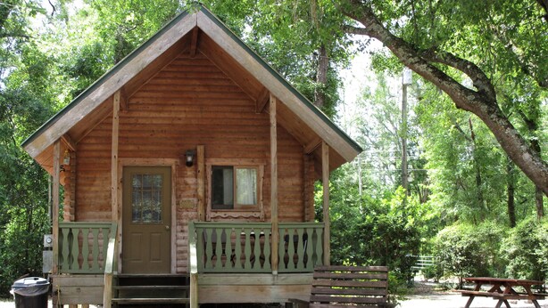 A wooden cabin with a porch, a front door, and a small window. - Charming cabin 25 with 1 bedroom and Wi-Fi, fitness room, Pool in fabulous Mayo (Mayo)