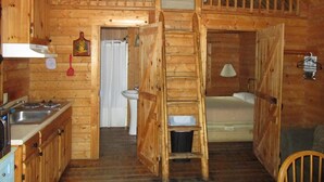 A wooden cabin with a kitchen, a bathroom, and a loft bedroom. - Charming cabin 25 with 1 bedroom and Wi-Fi, fitness room, Pool in fabulous Mayo (Mayo)