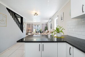 Enjoy meals in the kitchen and dining area, featuring a central island with a sink and a cozy seating space.