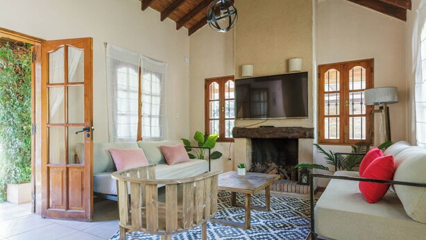 A cozy living room with a sofa, coffee table, and fireplace. - MOT Alzaga (Chacras de Coria)