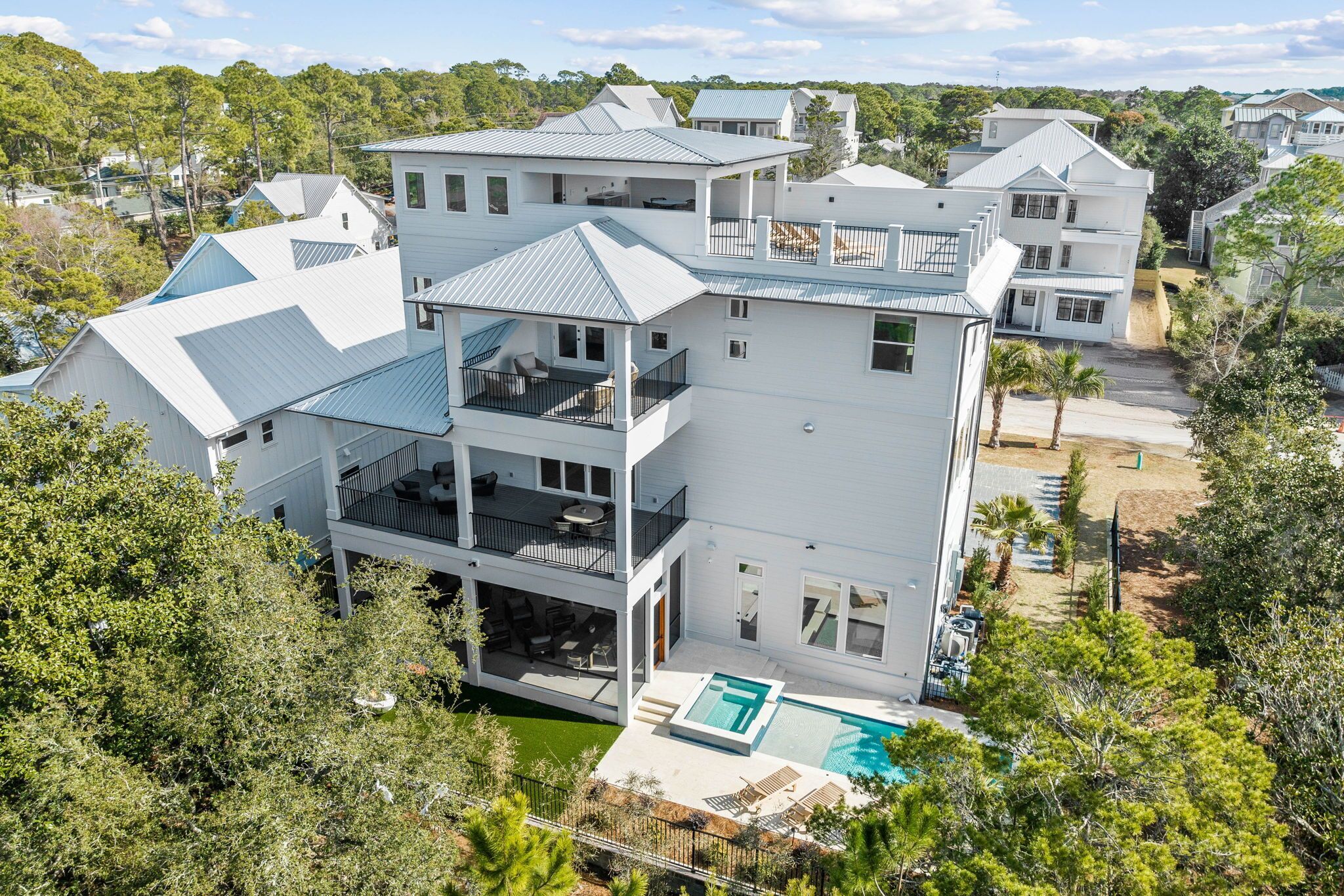 A multi-story residential building with a pool, balconies, and a view of the surrounding area.