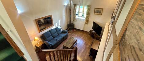 Una sala de estar acogedora con sofá, mesa, televisor y chimenea.