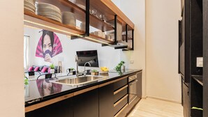 A modern kitchen with black cabinetry, a wooden countertop, and a built-in oven. - MOT Villa Embajada (Buenos Aires)