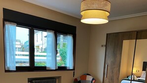 Habitación de hotel con dos camas, un espejo grande y una ventana con cortinas.