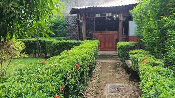 Stroll through the serene garden to a charming tea house surrounded by lush greenery and beautifully manicured hedges.