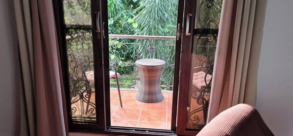 A sliding glass door leading to a balcony with a round table and chairs. - Hostal Casa San Mateo (León)