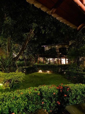 A garden with a gazebo, surrounded by lush greenery and flowering plants. - Hostal Casa San Mateo (León)