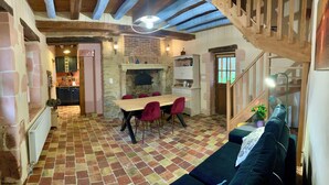 A cozy interior with a dining area, a fireplace, and a staircase. - Charming gîte in the heart of a water mill. 40 minutes from Le Mans and 15 minutes from Le Perche (Moncé-en-Saosnois)