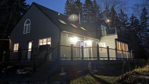 A two-story house with a covered porch and a fenced yard.