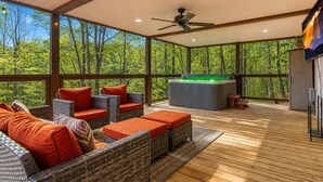 A covered outdoor area with wicker furniture, a hot tub, and a ceiling fan. - Hidden Haven, Hot Tub, FREE Attraction tickets each paid day, Game Room, WIFI!!! (Sevierville)