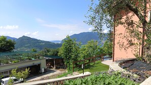 Paesaggio montuoso con un edificio in primo piano.