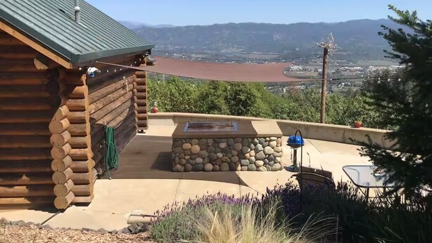 A log cabin with a stone fire pit and outdoor seating area, overlooking a valley. - Incredible Views - Orr Springs Rendezvous! (Ukiah)