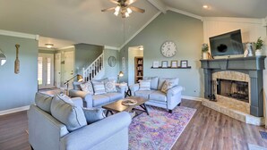A living room with a fireplace, two sofas, a coffee table, and a ceiling fan.