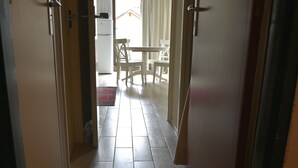 Ein Flur, der zu einem Essbereich mit einem weißen Tisch und Stühlen führt.