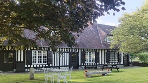 A traditional half-timbered house with a grassy lawn, white metal chairs, and a bench. - La LongeMer: Countryside & Sea Just a few kilometers from Veules-Les-Roses (Angiens)