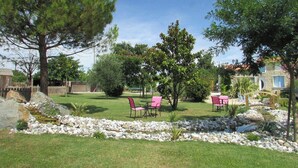 A landscaped garden with a pond, seating area, and stone walls. - Le Marais Salant - Gites for 8 people with swimming pool at Logis de Chalons à la mer (Le Gua)