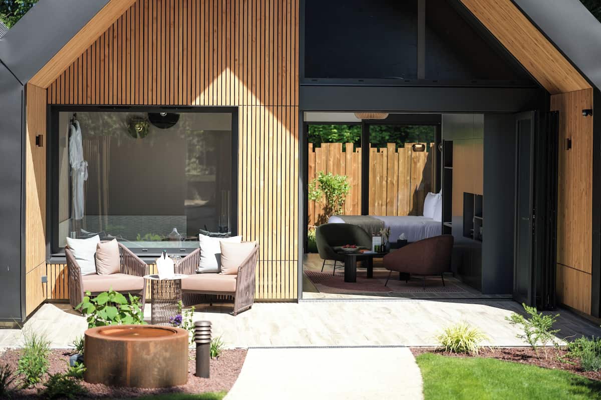 A modern outdoor living area with a sofa, chairs, and a dining table.