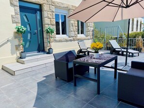 An outdoor patio with a table, chairs, and a large umbrella. - Spacious townhouse - 2 self-contained apartments for flexible living (Quimperlé)