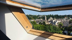 A skylight window with a view of a town featuring historic buildings and a church tower. - Spacious townhouse - 2 self-contained apartments for flexible living (Quimperlé)