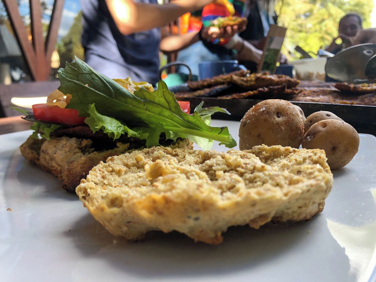 Un plato con comida que incluye un sándwich, una galleta y una ensalada.