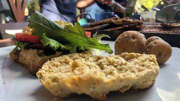 Un plato con comida que incluye un sándwich, una galleta y una ensalada.
