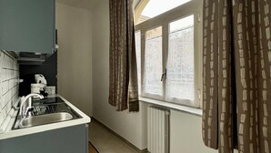 Eine moderne Küche mit eingebautem Spülbecken und einem Fenster mit gemusterten Vorhängen.